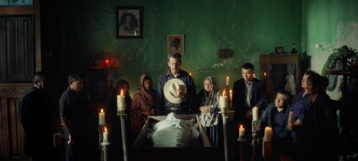 a group of people standing around a bed in a room