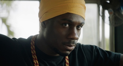 a man wearing a yellow turban with a red rope around his neck