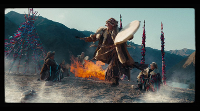 a man holding a frisbee standing next to a fire