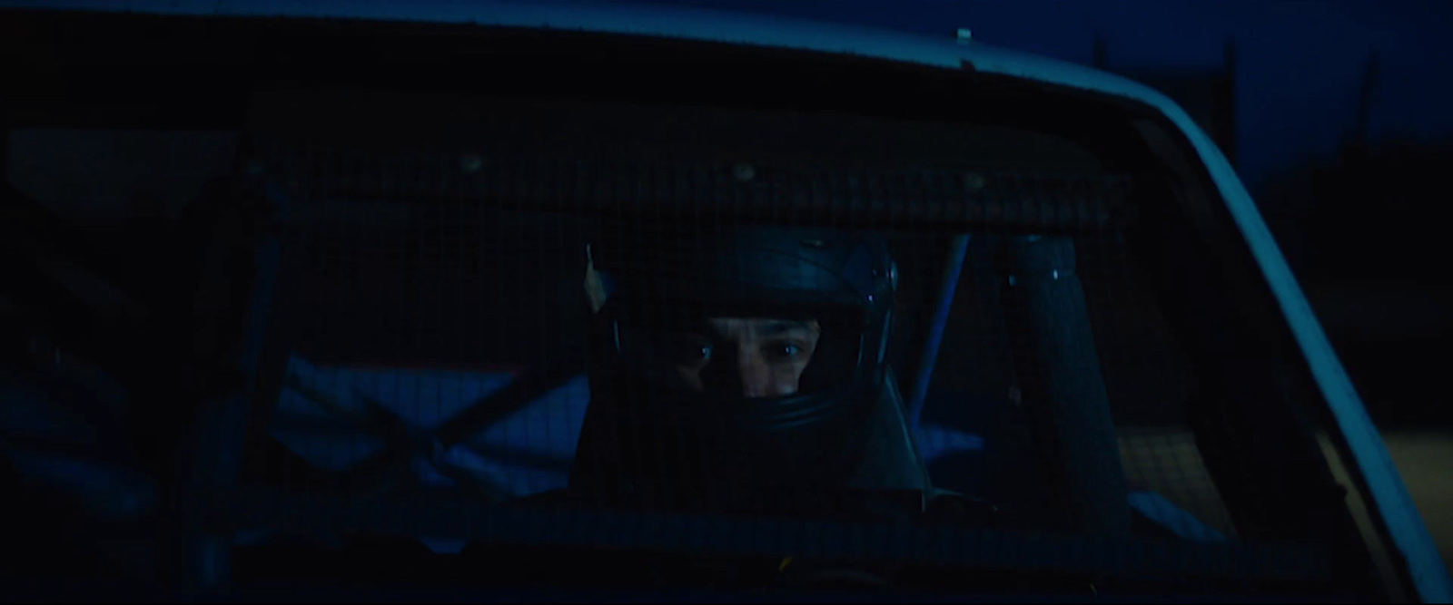 a man sitting in the back of a car in the dark