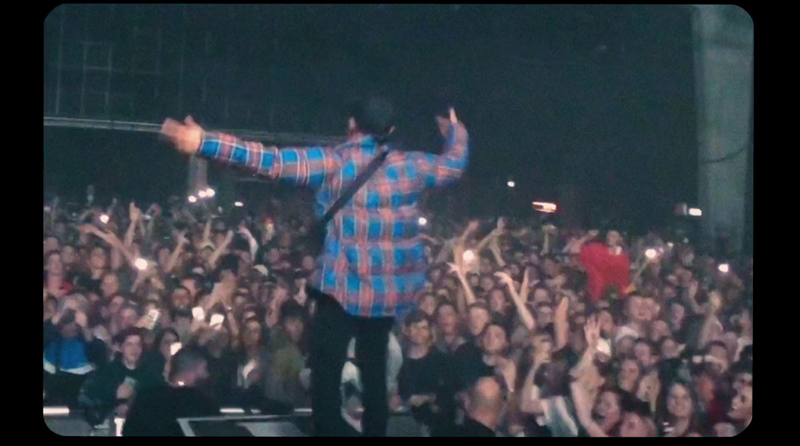 a man standing on top of a stage in front of a crowd