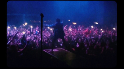 a man standing on top of a stage in front of a crowd