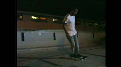 a man riding a skateboard down a street at night