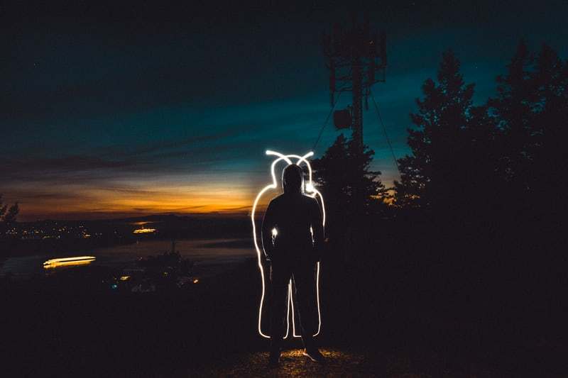 a man standing in the dark with a light painting on his face