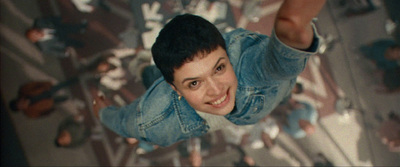 a young man in a denim jacket is flying through the air