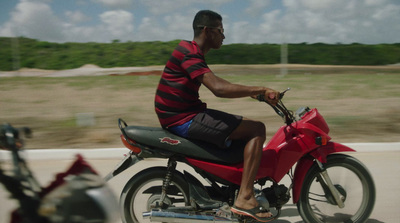 a man riding on the back of a red motorcycle