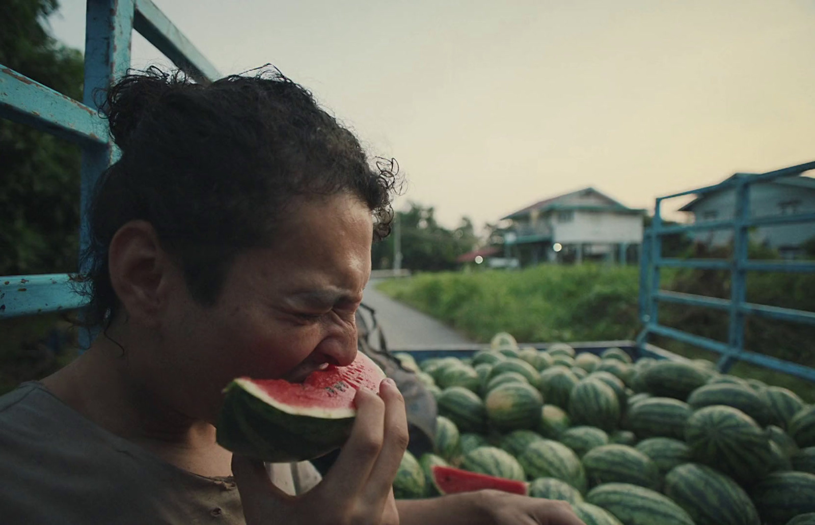 a man is eating a piece of watermelon