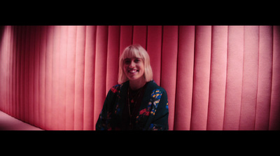 a woman standing in front of a red wall