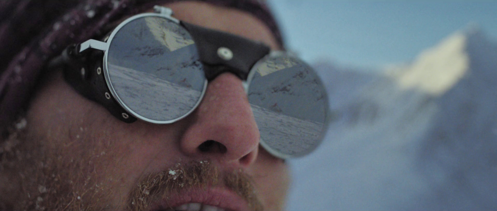 a man wearing a pair of ski goggles in the snow