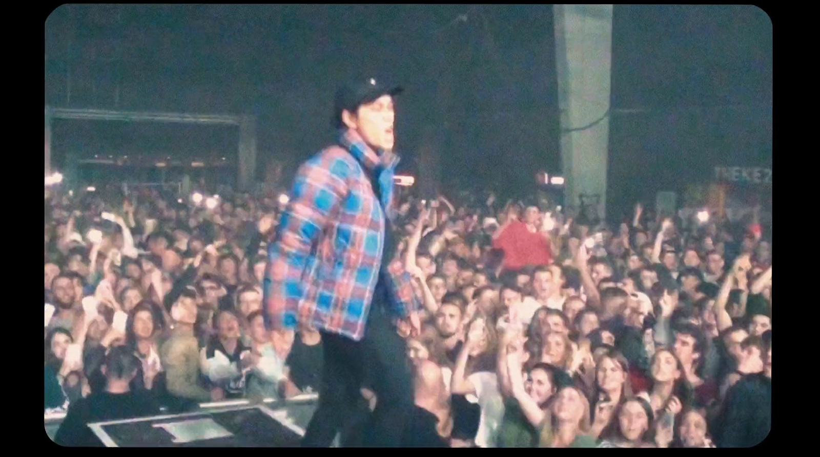 a man standing on top of a stage in front of a crowd