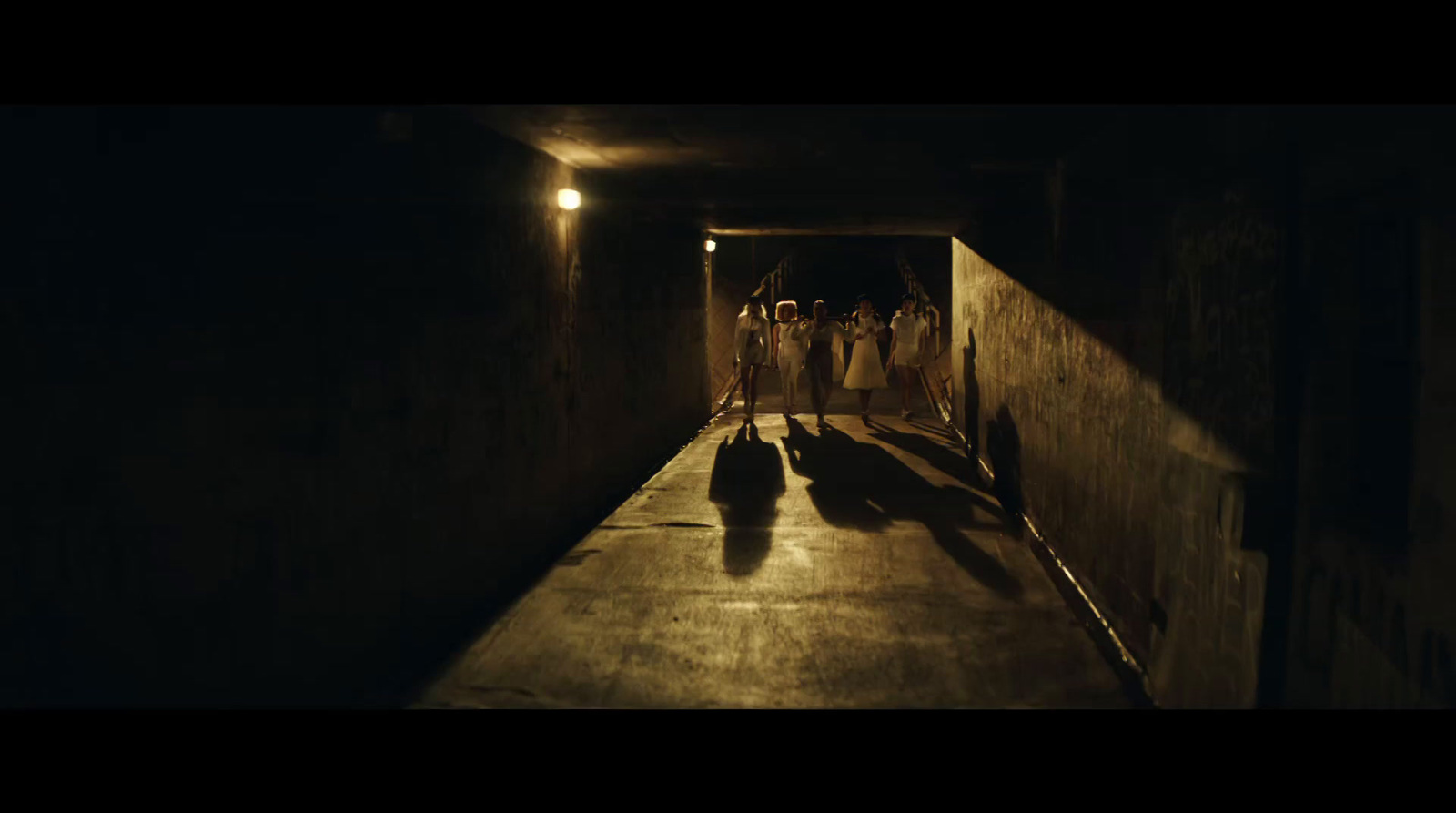 a group of people walking down a dark tunnel