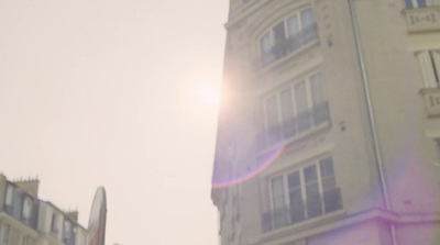 the sun is shining brightly over a tall building