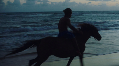 a man riding a horse on the beach