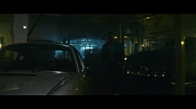 a man standing next to a car in a garage