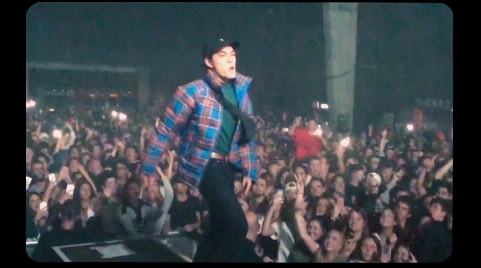 a man standing on top of a stage in front of a crowd