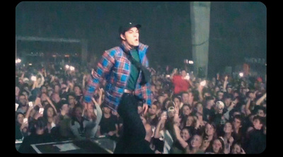 a man standing on top of a stage in front of a crowd