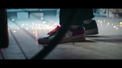 a person standing on a sidewalk with a pair of sneakers