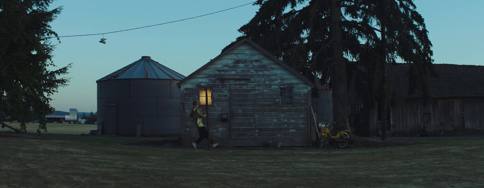 a man standing outside of a building next to a tree