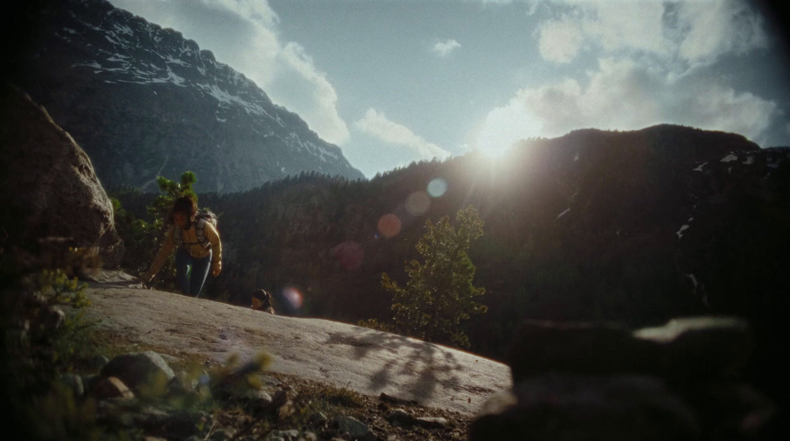 a man with a backpack standing on top of a mountain