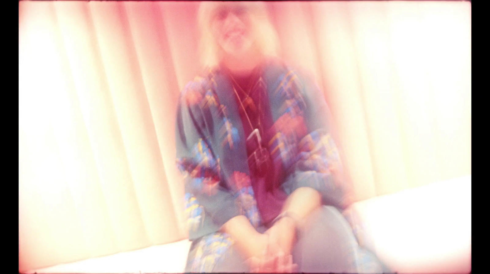 a blurry photo of a woman sitting on a bed