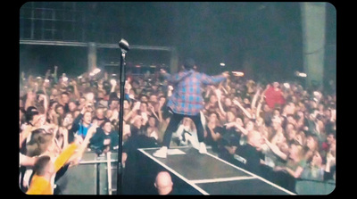 a man standing on top of a stage in front of a crowd