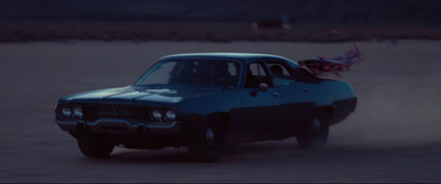 a blue car driving down a dirt road