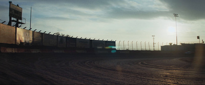 a train traveling down tracks next to a fence