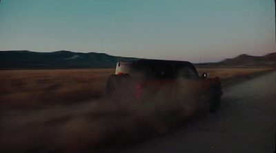 a truck driving down a dirt road in the desert