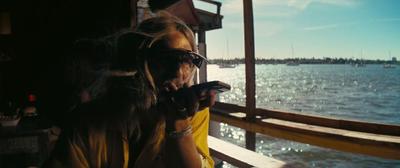 a woman is on her cell phone by the water