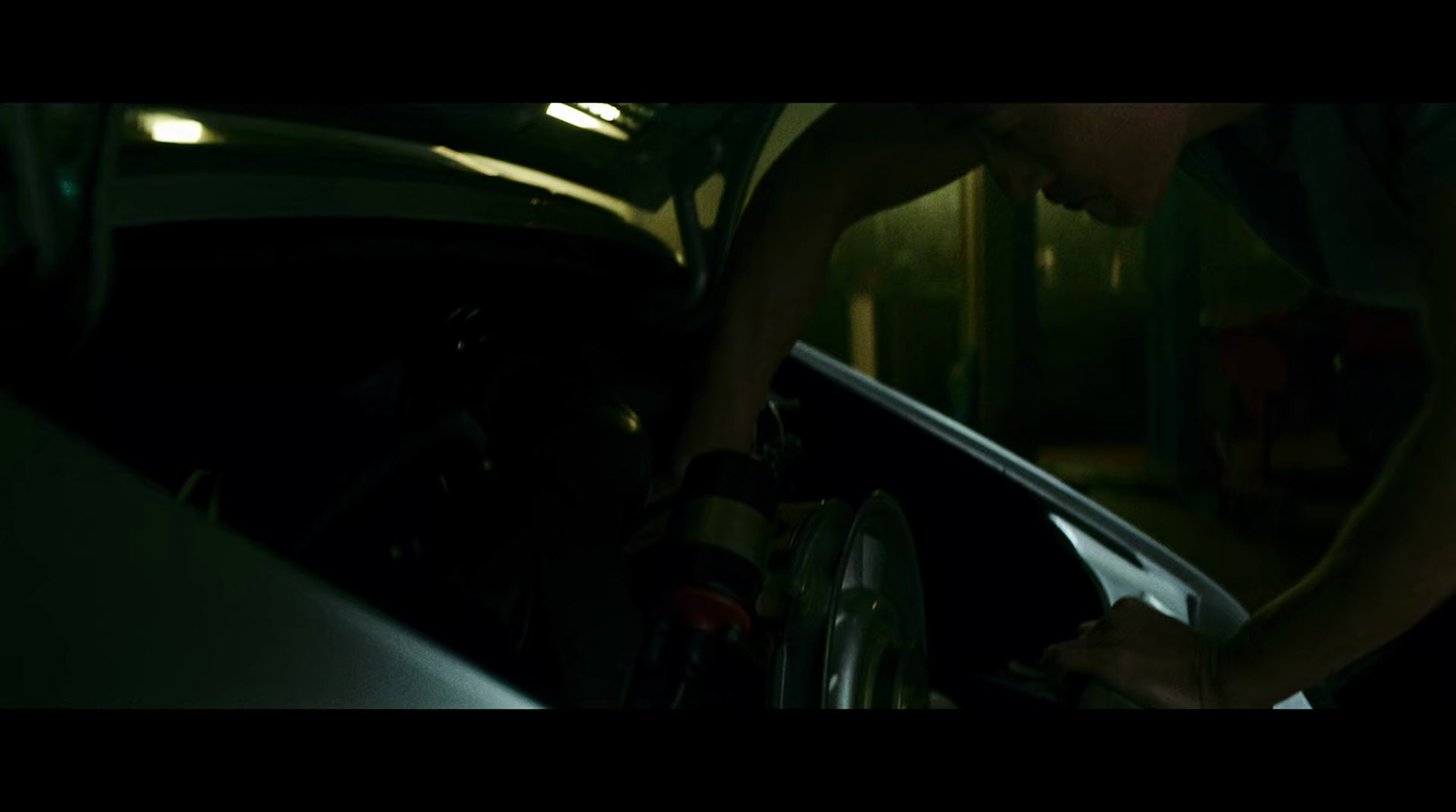 a man working on a car in the dark