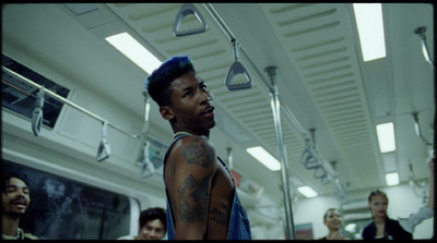 a man with tattoos on his arm standing in a subway car