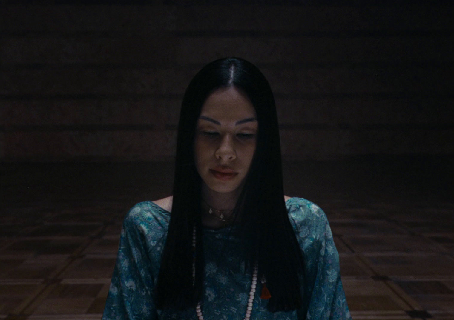 a woman with long black hair standing in a room