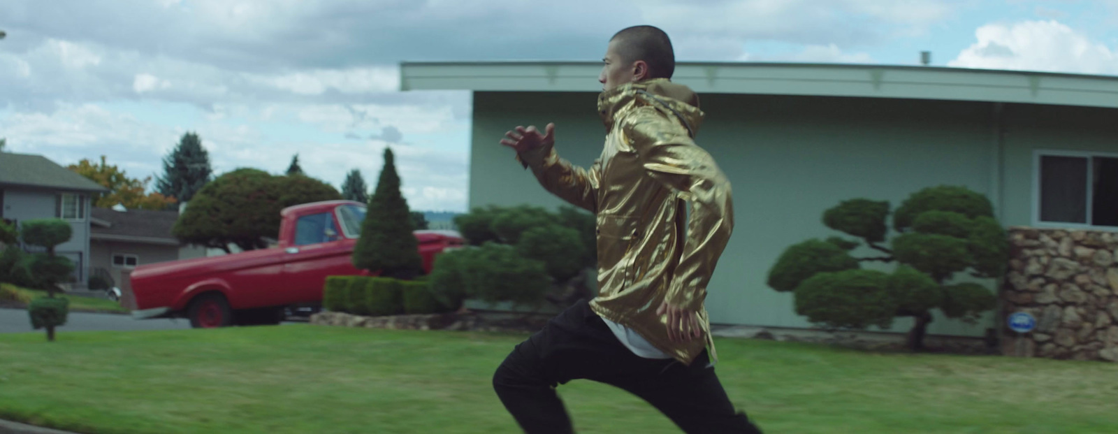 a man in a gold shirt is skateboarding on the street