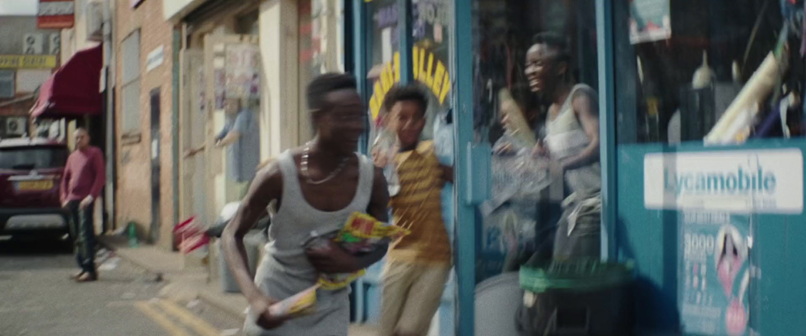 a couple of men walking down a street next to a store