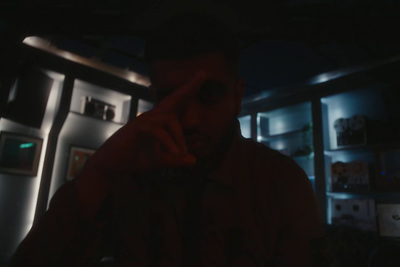 a man in a dark room talking on a cell phone