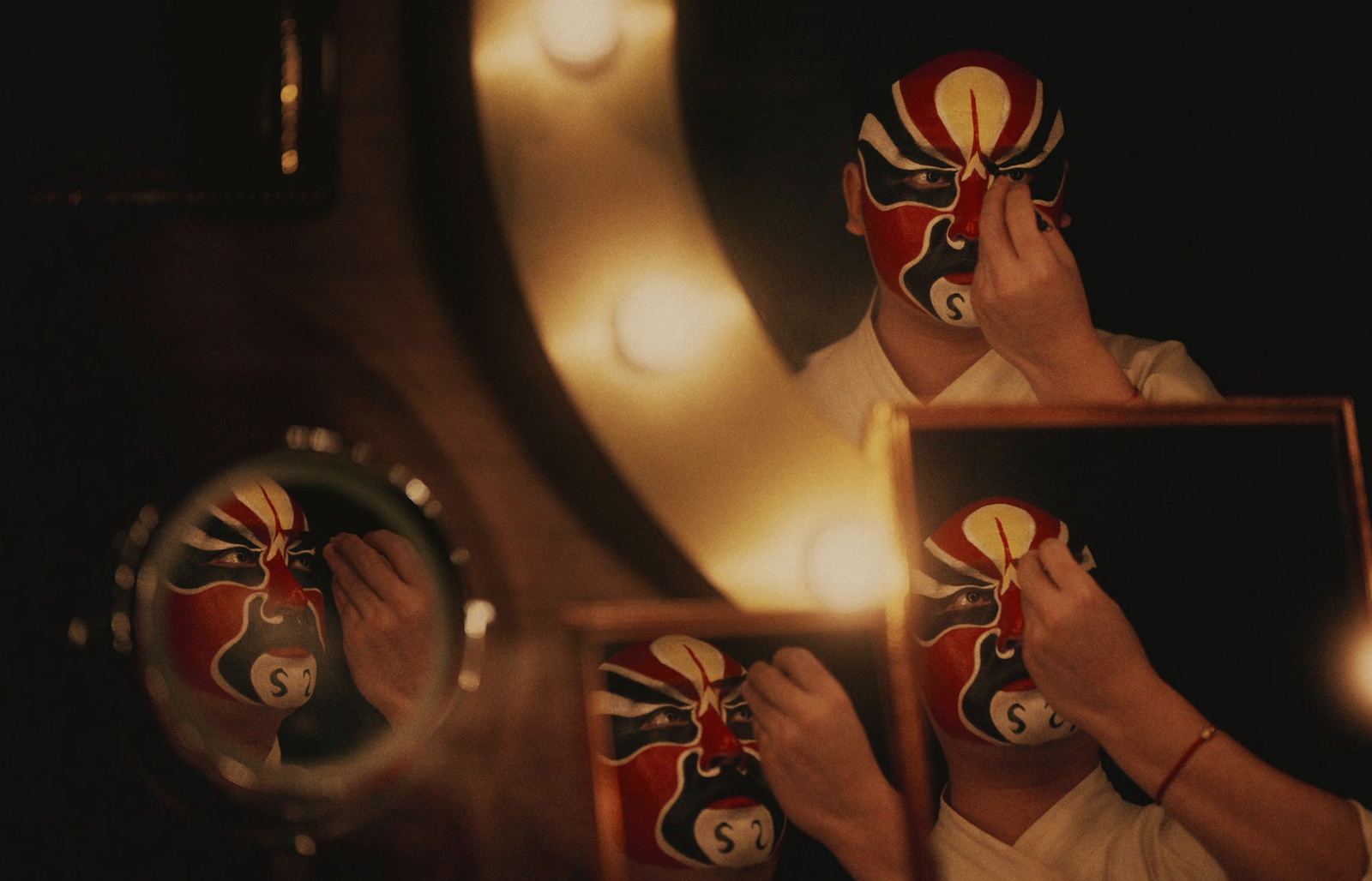 a person holding a mask in front of a mirror