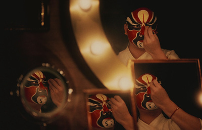 a person holding a mask in front of a mirror