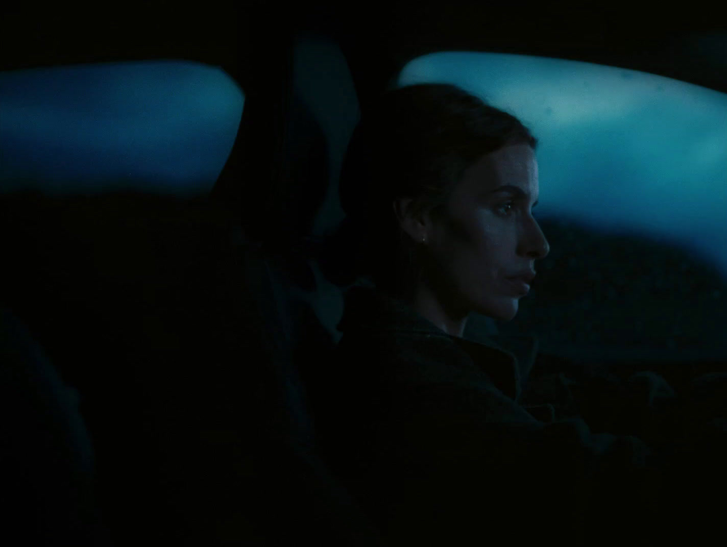 a woman driving a car in the dark