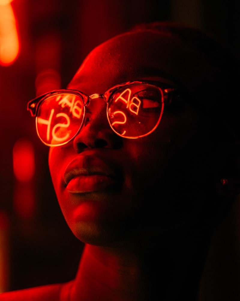 a woman wearing red glasses with the words bad ass on them