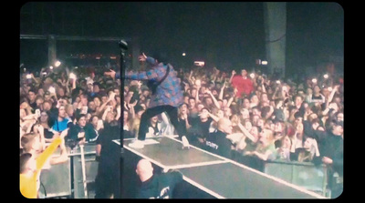 a man standing on top of a stage in front of a crowd