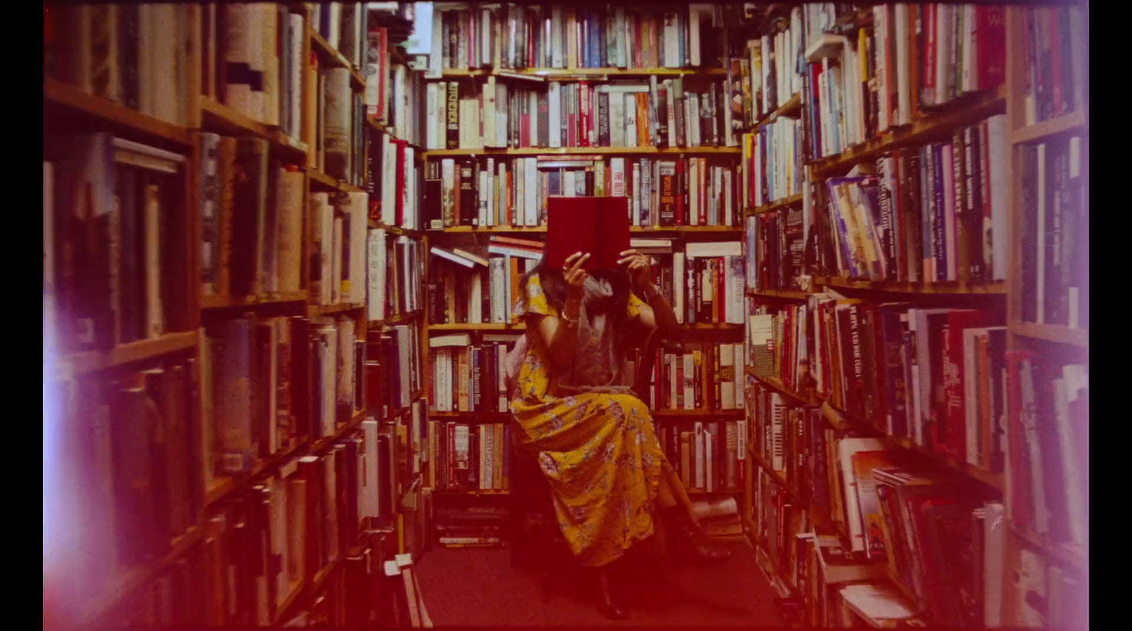 a woman sitting in a library with a book in her hand