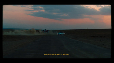 a car driving down a dirt road next to a truck