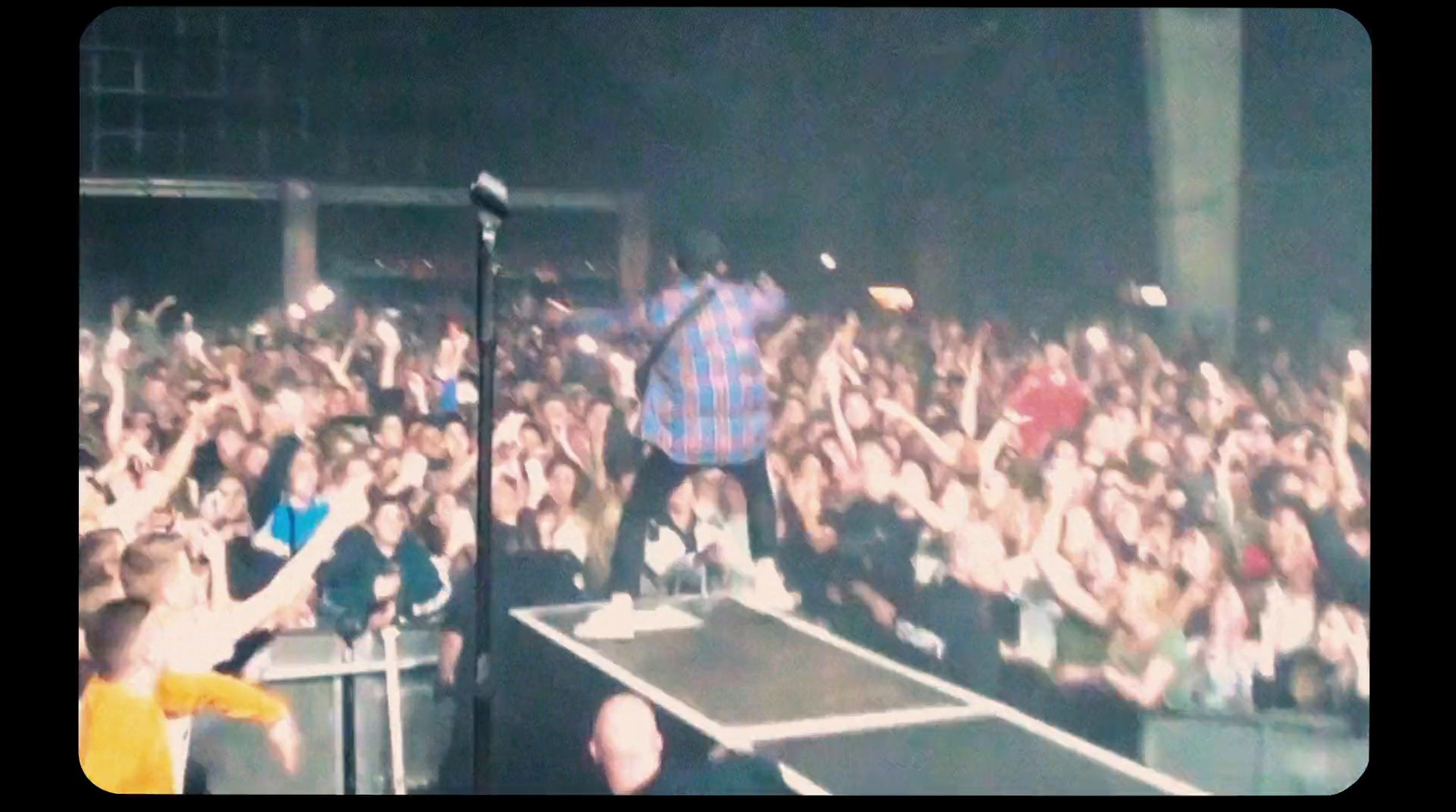 a man standing on top of a stage in front of a crowd