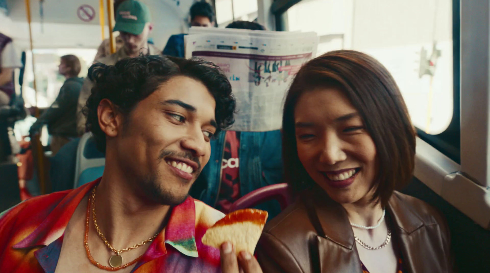 a man and a woman eating food on a bus