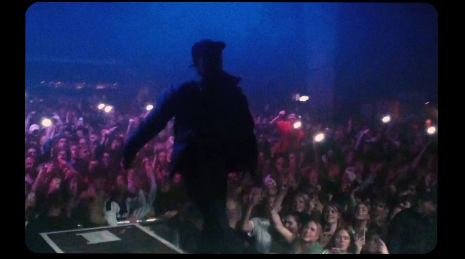 a man standing on top of a stage in front of a crowd