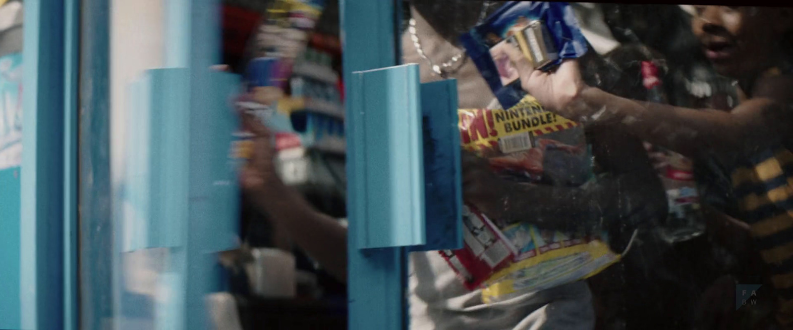 a man holding a bag of chips in front of a store window