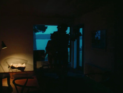 a man standing in a dark room next to a table