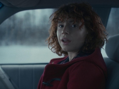 a woman with red hair sitting in a car