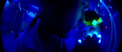 a man looking at his cell phone in a dark room