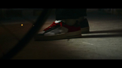 a person wearing red and black sneakers standing on a street